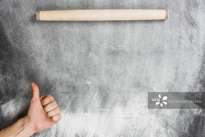 面粉背景，手持擀面杖做出“OK”手势图片素材