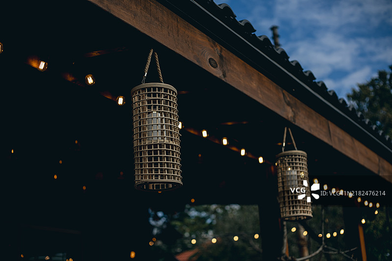 带有悬挂灯笼和串灯的凉亭结构。图片素材
