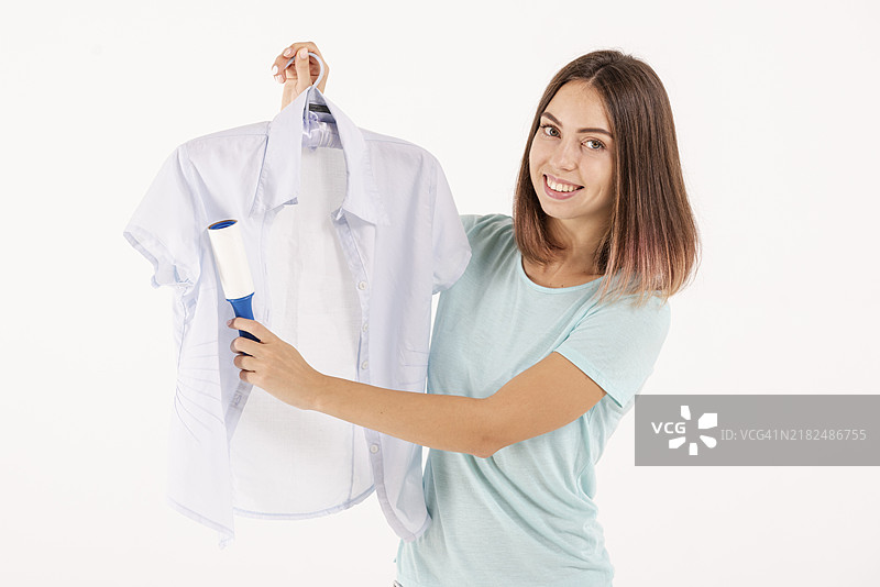 中景快乐的女性在使用粘毛滚筒图片素材