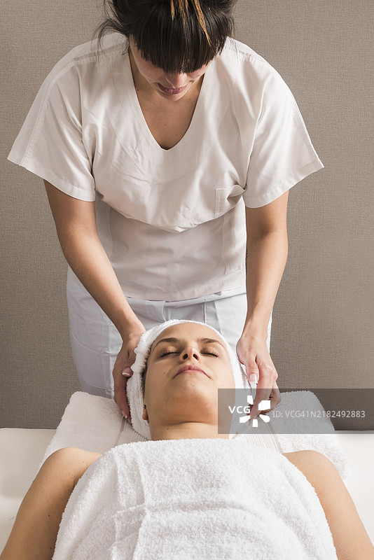 女性治疗师为女性包裹头巾的特写镜头图片素材