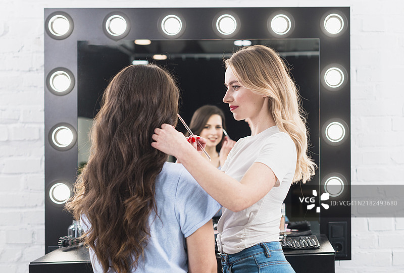 金发女郎正在用刷子为客户化眼妆图片素材