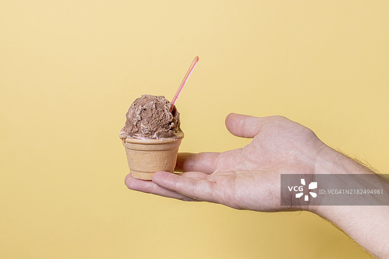 手握小巧的巧克力冰淇淋球图片素材