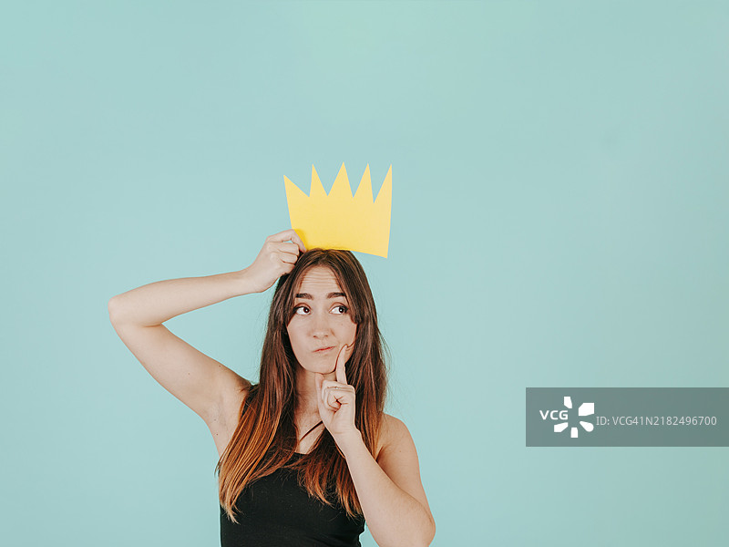戴着纸皇冠的沉思女性图片素材