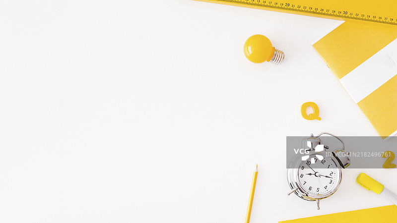 闹钟灯泡旁边的各种文具图片素材