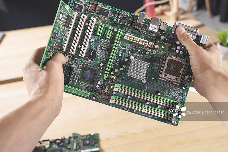 男性技术人员手持计算机主板的特写镜头图片素材