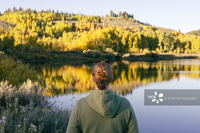 一位女性在怀俄明州大提顿国家公园的湖边眺望。图片素材