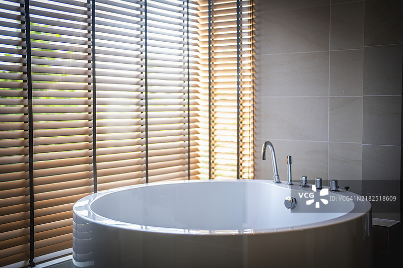 浴缸旁墙上挂着两件浴袍图片素材