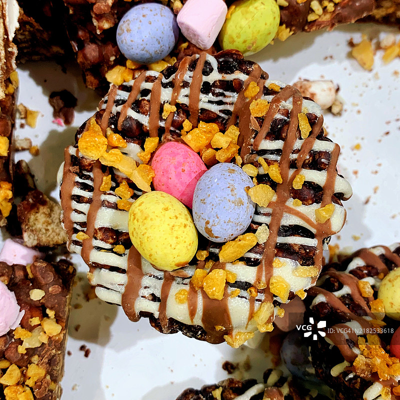 特写镜头展示自制的白巧克力、焦糖和花生复活节饼干，上面装饰着漂亮的牛奶巧克力蛋，拍摄于2024年3月的美国。图片素材