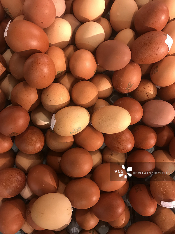新鲜农场鸡蛋。有机、散养的英国鸡蛋。棕色、白色和斑点的鸭蛋和母鸡蛋，摆放在2024年6月的农贸市场摊位上。图片素材