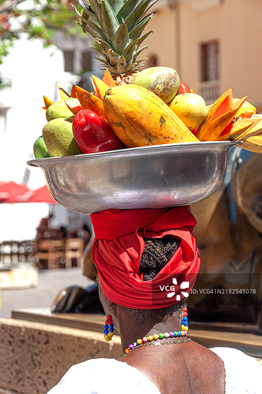卡塔赫纳的帕伦奎拉，头上顶着菠萝、西瓜、木瓜，围着红色围巾。图片素材