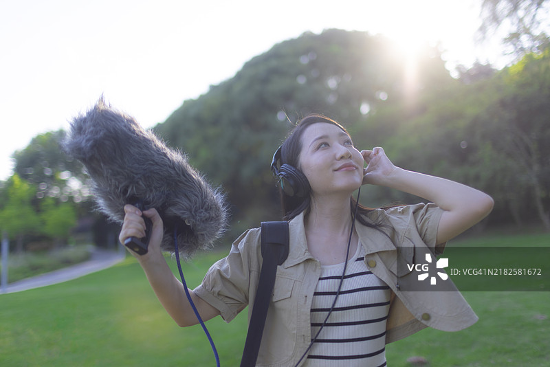 亚洲女性录音师使用防风罩的霹雳麦克风录制自然声音图片素材