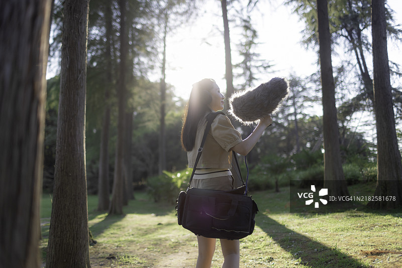 亚洲女性录音师使用防风罩的霰弹枪麦克风录制自然声音图片素材