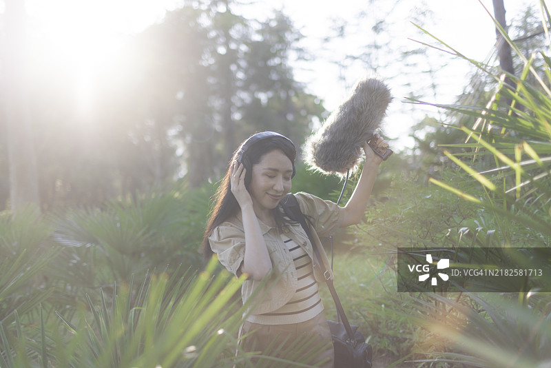 亚洲女性录音师使用防风罩的霹雳麦克风录制自然声音图片素材