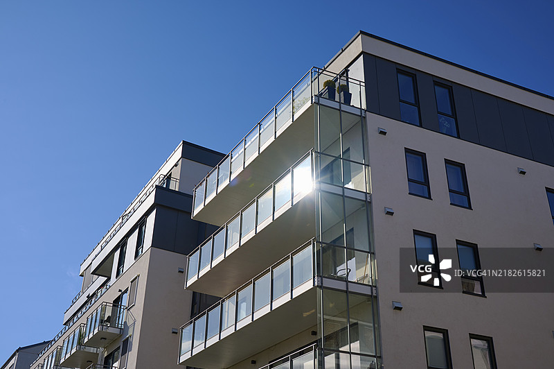 现代住宅建筑，带有玻璃阳台，蓝天映衬下反射着阳光，挪威罗姆斯达尔的莫尔德，欧洲图片素材