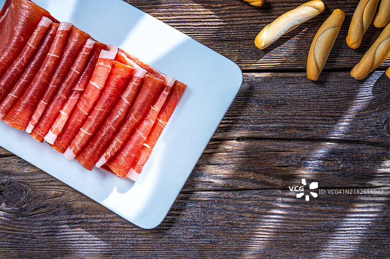 西班牙的塞拉诺火腿小吃，伊比利亚火腿在木板上整齐叠放图片素材
