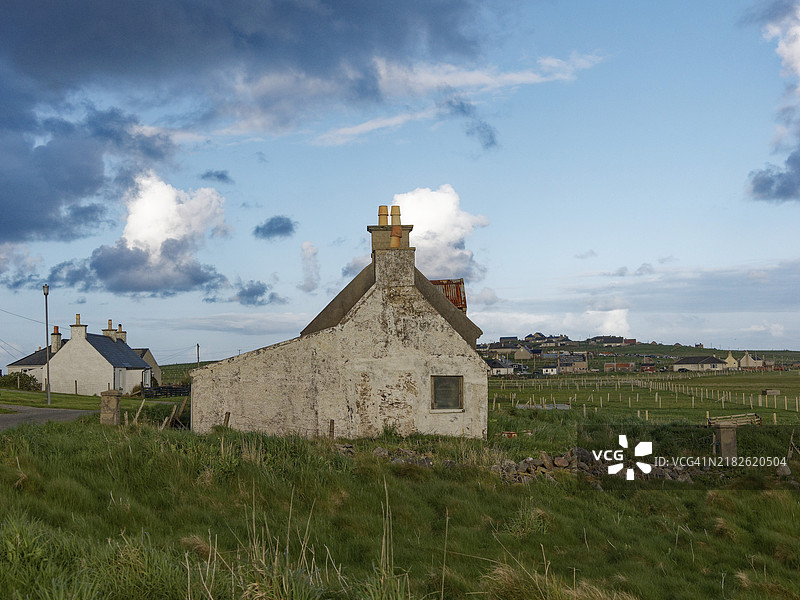 一座古老的乡村房屋在清澈的蓝天和零星的白云下。Fivepenny, Harry & Lewis 外赫布里底群岛，苏格兰，英国图片素材