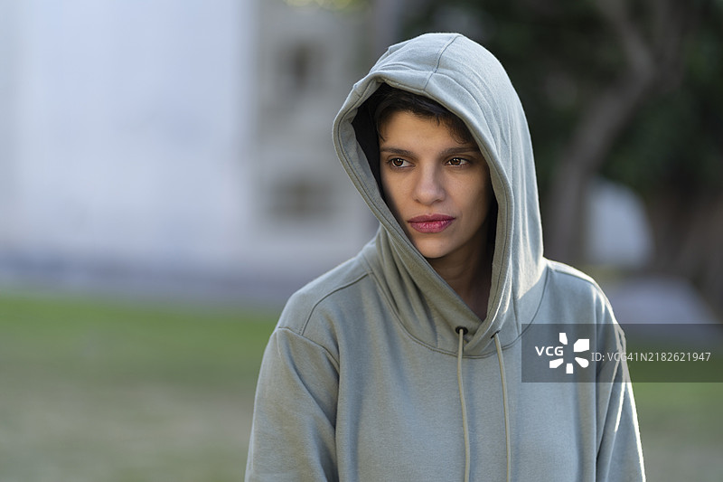 短发、外表阳刚、表情严肃的女性穿着连帽衫图片素材