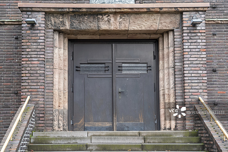 一座老建筑的入口，配有双开门和砖砌墙面图片素材