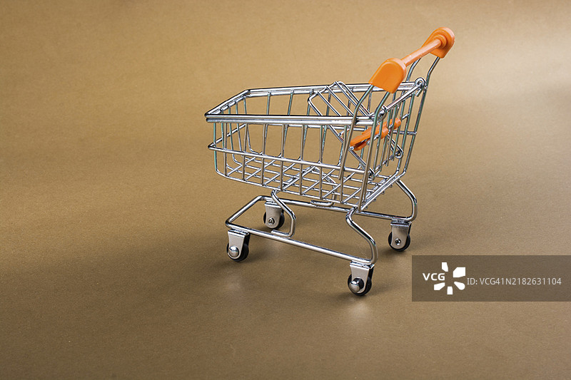 小模型购物车在棕色背景上图片素材