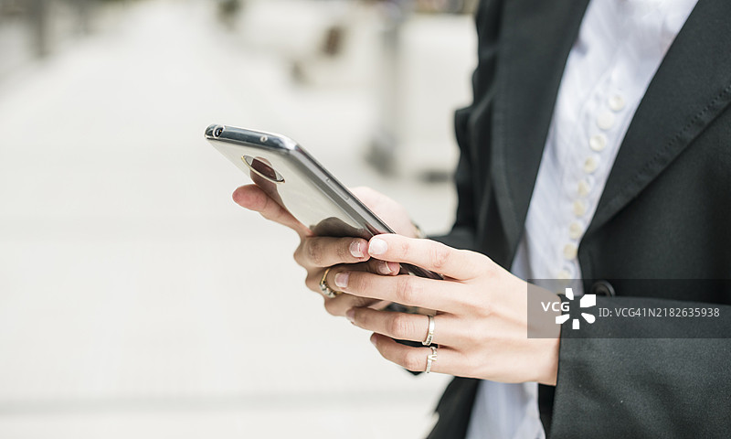 年轻女商人近距离使用智能手机图片素材
