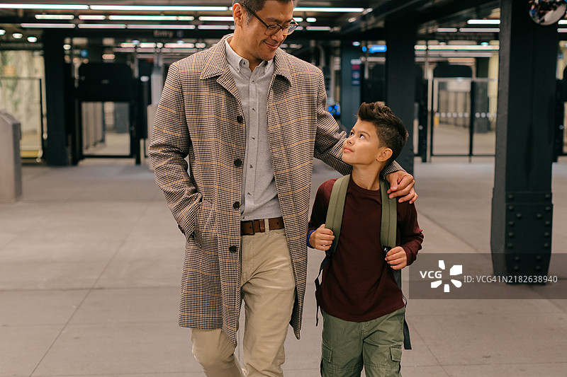 在纽约市地铁站，父亲或叔叔带着儿子/侄子走向学校的特写动作照片图片素材