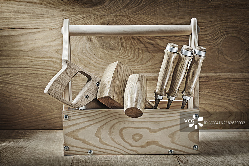 复古木匠工具放在木箱中，背景为木质表面图片素材