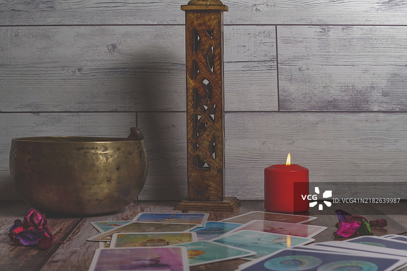 塔罗牌、藏式碗和蜡烛放在木桌上图片素材