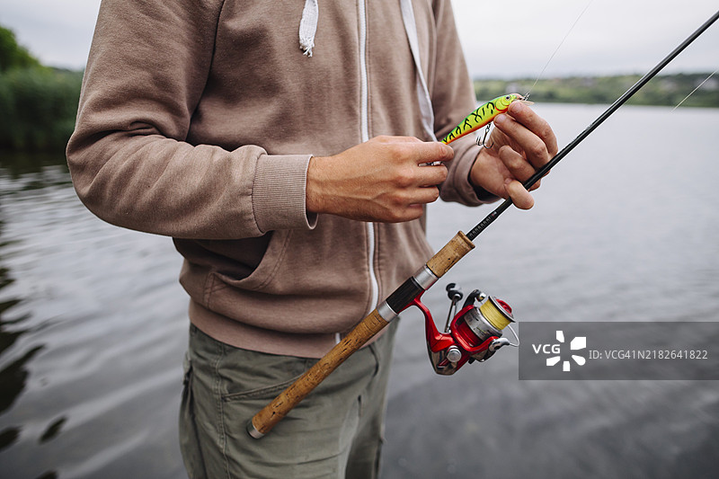 男人的手握着钓鱼饵杆图片素材