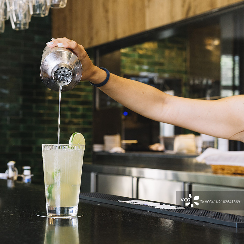 特写女性手在酒吧台调制鸡尾酒图片素材