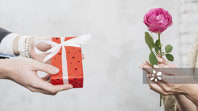 剪裁的男人给女人送礼物和玫瑰图片素材