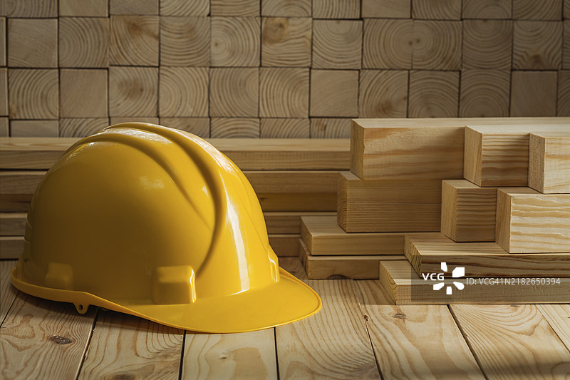 木质背景上的黄色安全帽图片素材