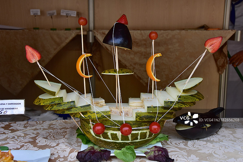 装饰性的水果和蔬菜船，水果和蔬菜的船，茄子，西瓜，草莓，橙皮，沙拉叶，桌面装饰，艺术化的蔬菜，装饰水果摊位图片素材