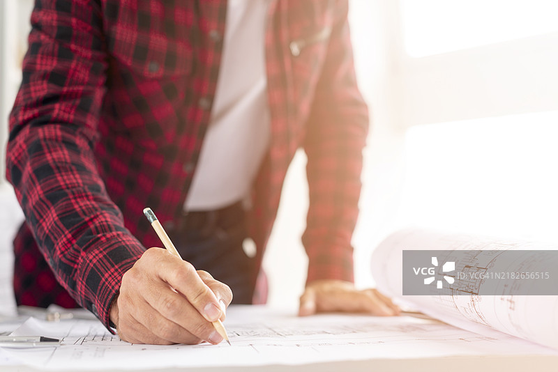 中景拍摄的男子正在绘制建筑项目图片素材