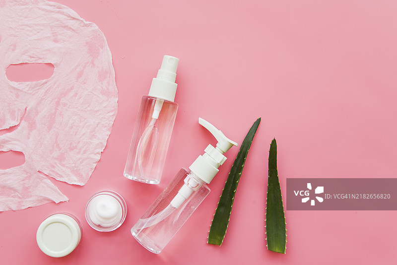 从上方看芦荟喷雾瓶保湿霜，粉色背景图片素材