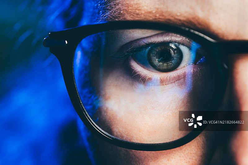 特写肖像：女性在电脑上工作，眼镜中反射出图表。数据分析统计信息商业科技。图片素材