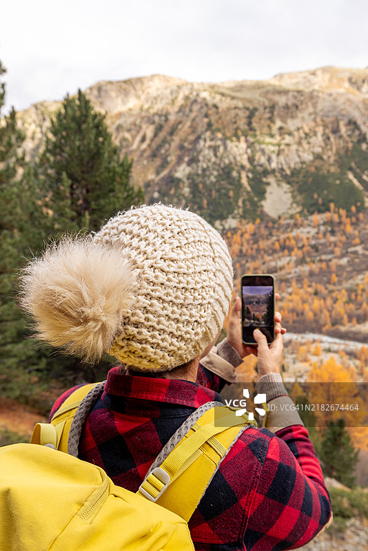 徒步旅行者用智能手机拍摄美丽的山景图片素材