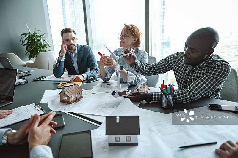 一组专业人士讨论郊区住房的建设及其配备替代能源的方案图片素材