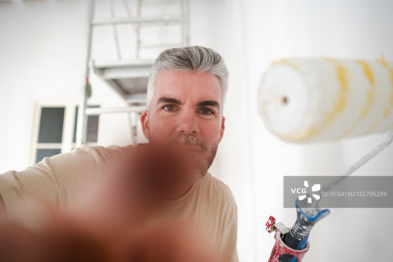 画家在给墙壁上色时自拍图片素材