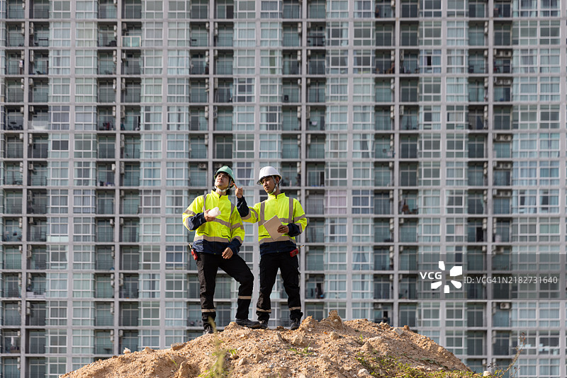 两名工程师正在检查住宅建筑项目的进展，确保一切正常，以便在进入下一个阶段之前及早发现潜在问题，保持项目顺利进行。图片素材