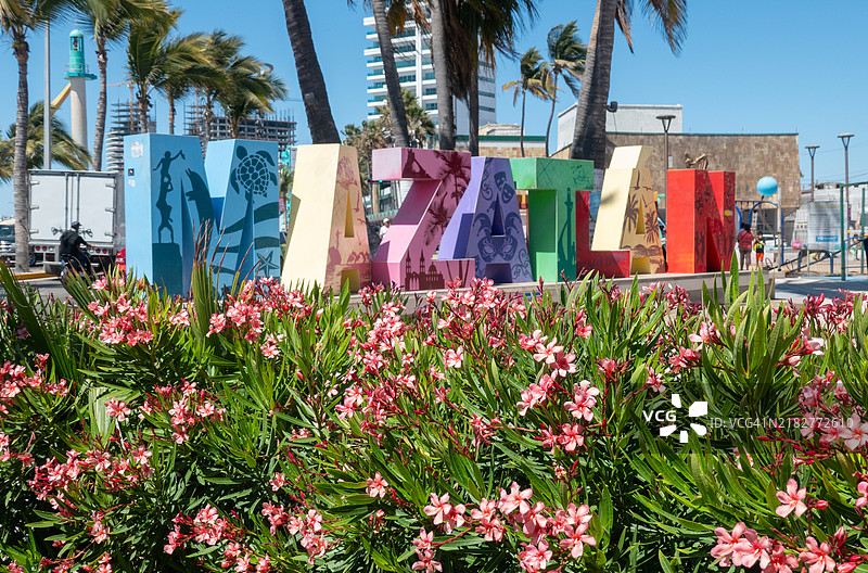 墨西哥马萨特兰市中心的MAZATLAN字母雕塑，前景有鲜花。图片素材