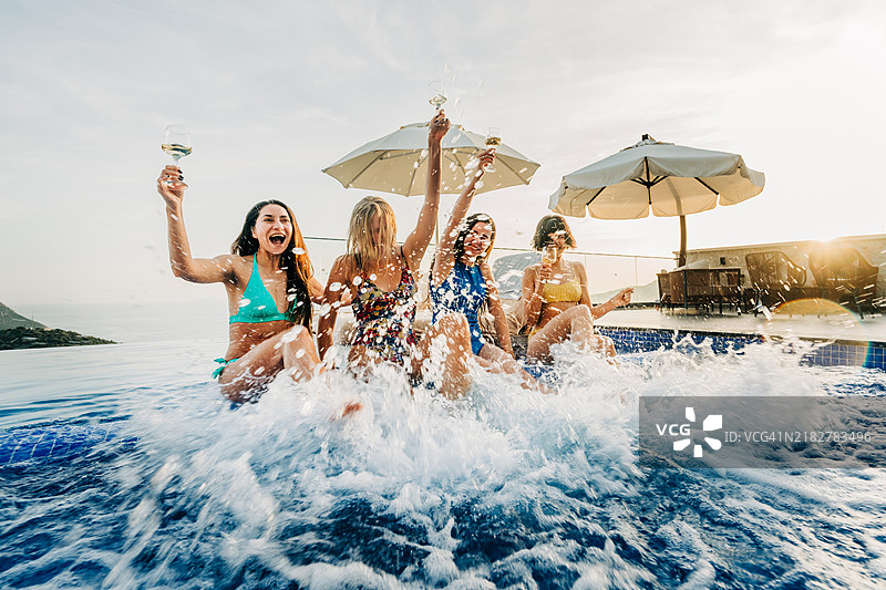 女朋友们在泳池里嬉戏、欢笑，享受乐趣。图片素材