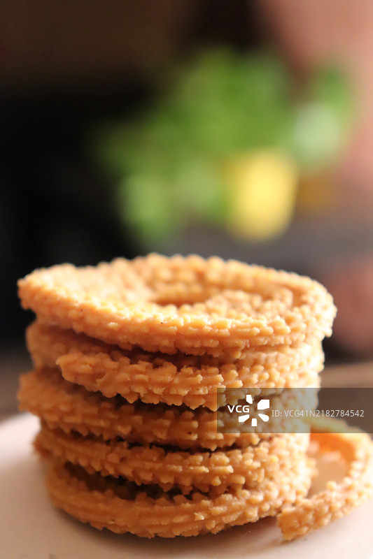 白色陶瓷盘中的脆脆小吃Murukku特写/静物图片素材