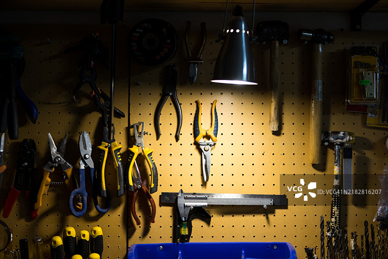 整理好的工作坊桌子，上面摆放着工具和用品。螺丝刀、钳子、锤子、工作台、木工、维修和改进。图片素材