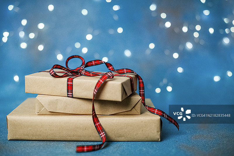 节日蓝色背景上的牛皮纸包装圣诞礼物图片素材