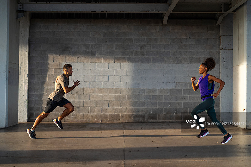 运动员在城市桥下进行短跑训练，为马拉松做准备，展现了他们在城市背景下对健身的热情。图片素材