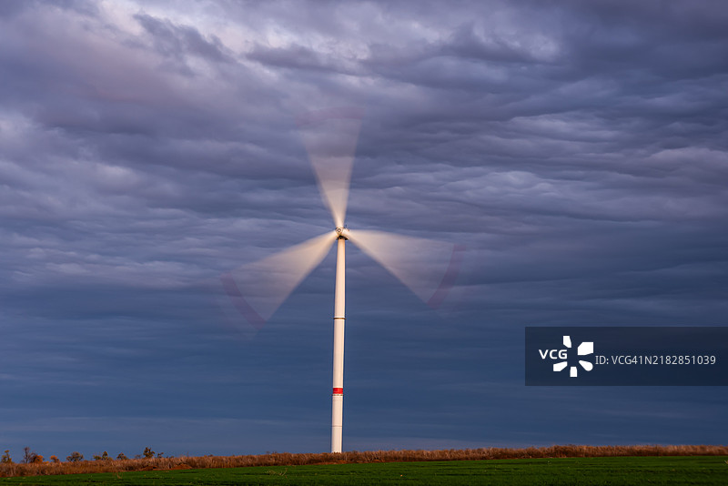 在剧烈天气下的风力涡轮机。绿色能源概念图片素材