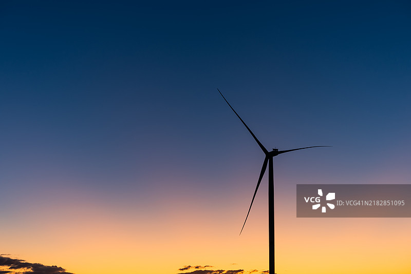 日落时的风力涡轮机。绿色能源概念图片素材