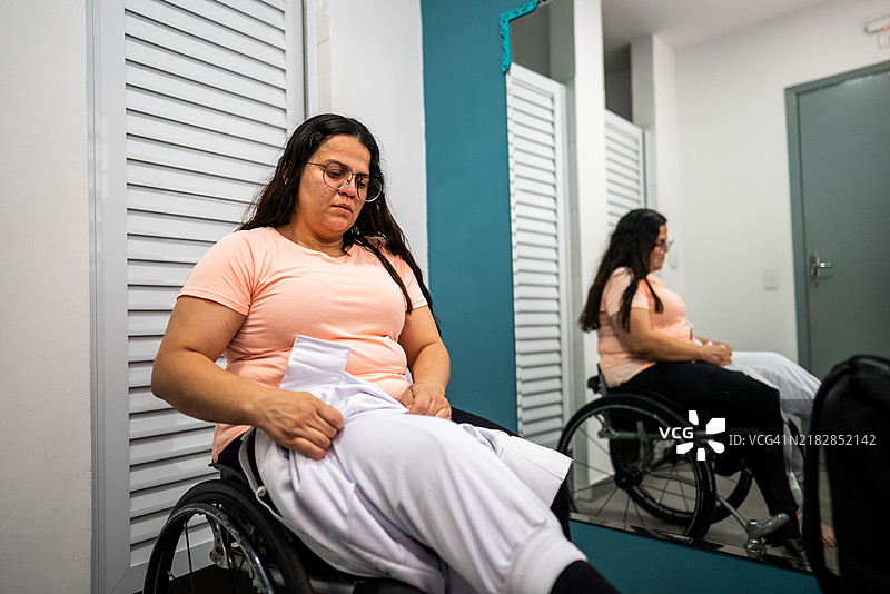 中年轮椅女性在更衣室准备练习击剑图片素材