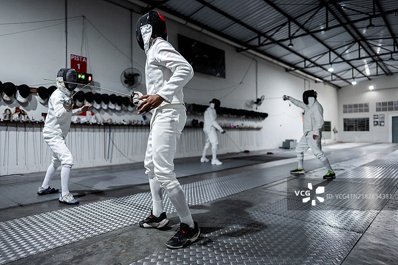 男性在健身俱乐部练习击剑图片素材