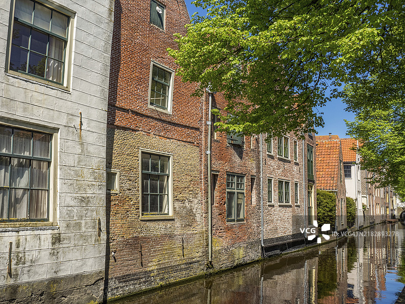 阿尔克马尔，荷兰，阳光明媚的蓝天下运河旁的砖房图片素材